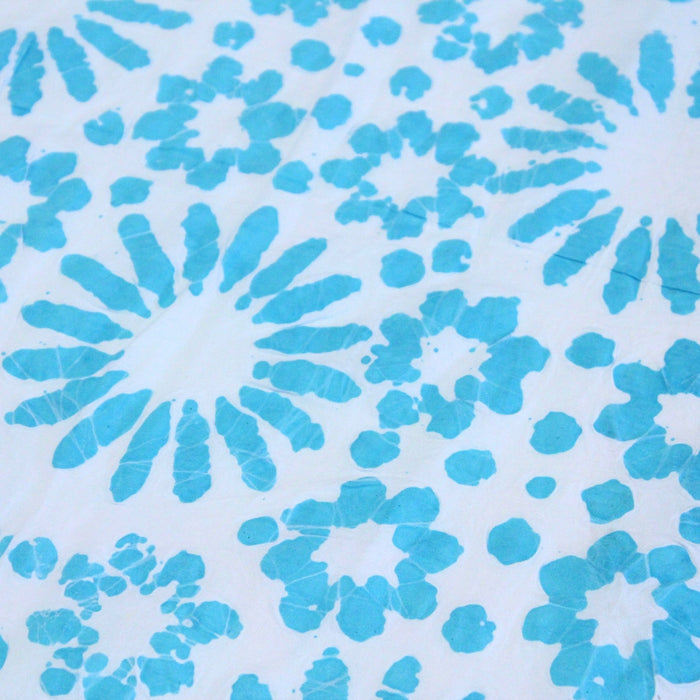 Tissu de coton batik gaufré aux fleurs et soleils bleu turquoise, fond bleu ciel - TissusPapi.com