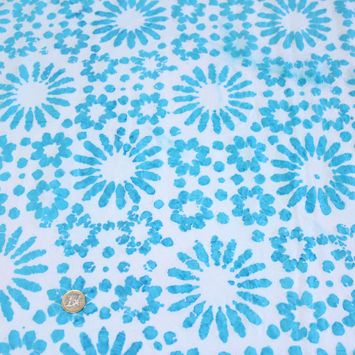 Tissu de coton batik gaufré aux fleurs et soleils bleu turquoise, fond bleu ciel - TissusPapi.com