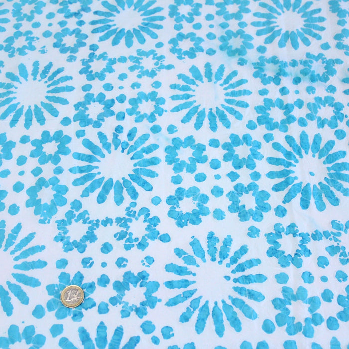 Tissu de coton batik gaufré aux fleurs et soleils bleu turquoise, fond bleu ciel - TissusPapi.com