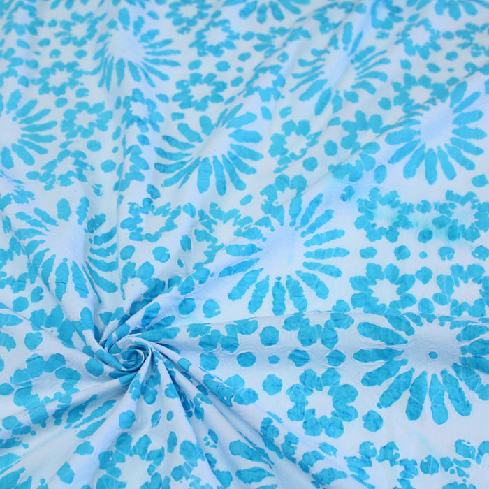 Tissu de coton batik gaufré aux fleurs et soleils bleu turquoise, fond bleu ciel - TissusPapi.com