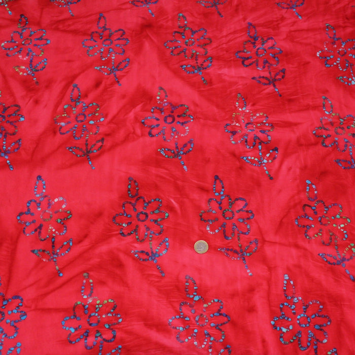 Tissu de coton batik gaufré aux fleurs bleues, fond rouge - TissusPapi.com