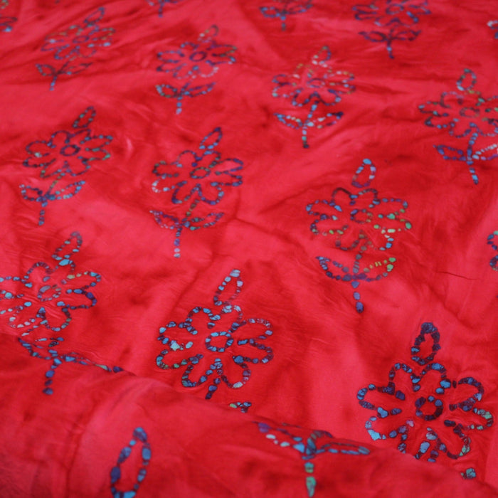 Tissu de coton batik gaufré aux fleurs bleues, fond rouge - TissusPapi.com