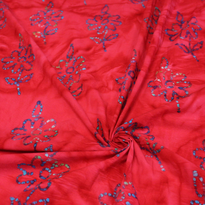 Tissu de coton batik gaufré aux fleurs bleues, fond rouge - TissusPapi.com