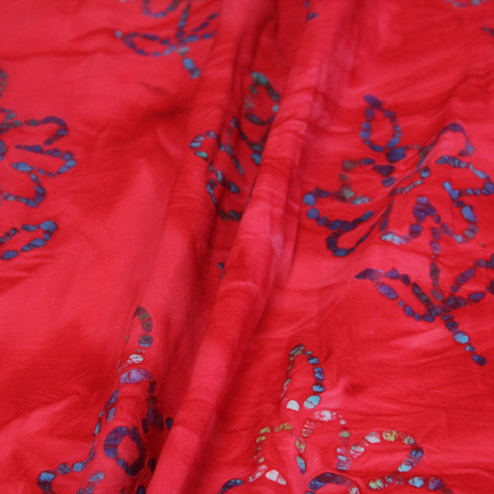 Tissu de coton batik gaufré aux fleurs bleues, fond rouge - TissusPapi.com
