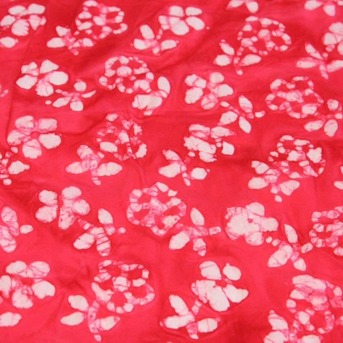 Tissu de coton Batik fond rouge clair aux fleurs blanches - TissusPapi.com
