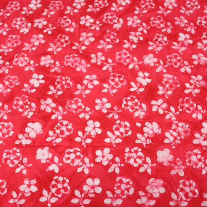 Tissu de coton Batik fond rouge clair aux fleurs blanches - TissusPapi.com
