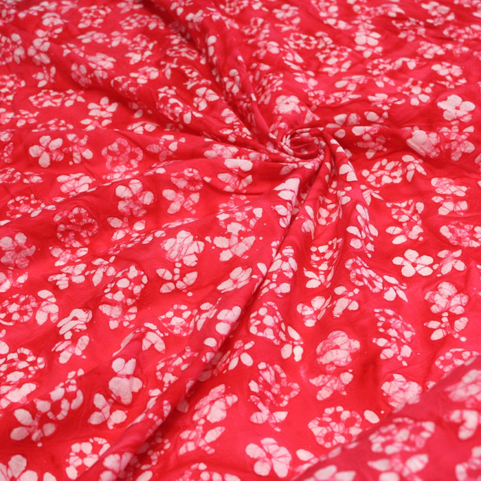 Tissu de coton Batik fond rouge clair aux fleurs blanches - TissusPapi.com