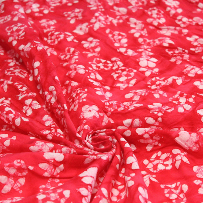 Tissu de coton Batik fond rouge clair aux fleurs blanches - TissusPapi.com