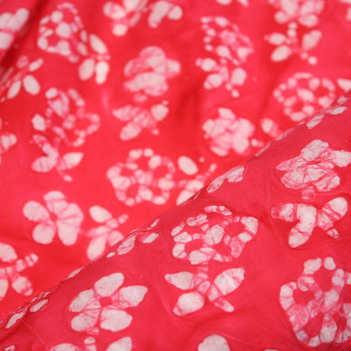 Tissu de coton Batik fond rouge clair aux fleurs blanches - TissusPapi.com