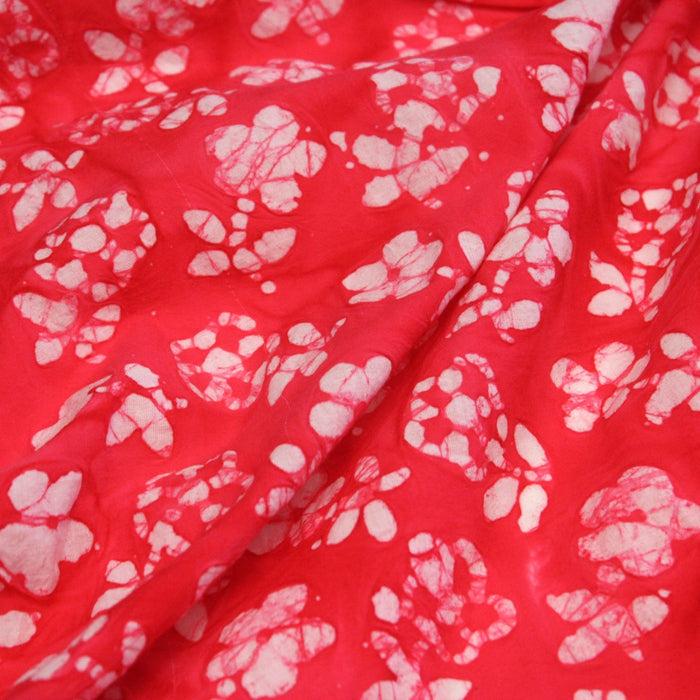 Tissu de coton Batik fond rouge clair aux fleurs blanches - TissusPapi.com