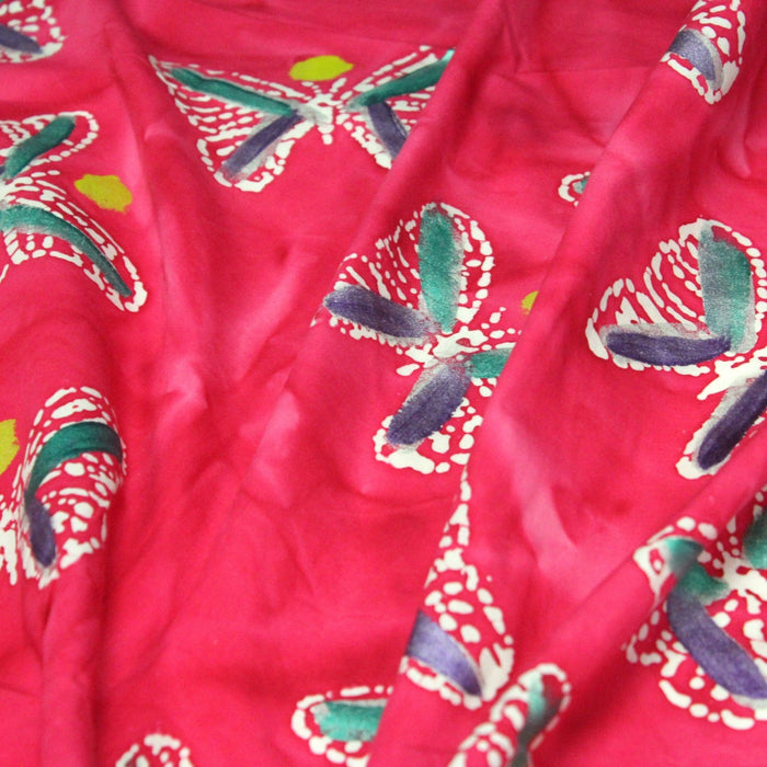 Tissu de coton batik aux papillons blancs, fond rose fuchsia - TissusPapi.com