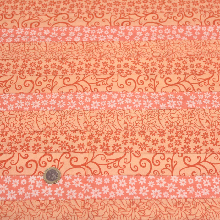 Tissu de coton batik patchwork aux fleurs variées, tons orange et pêche - TissusPapi.com