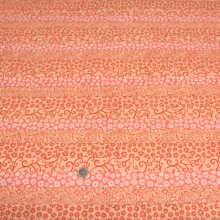 Tissu de coton batik patchwork aux fleurs variées, tons orange et pêche - TissusPapi.com