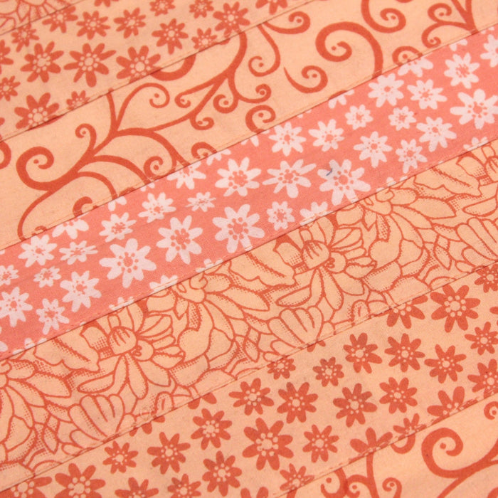 Tissu de coton batik patchwork aux fleurs variées, tons orange et pêche - TissusPapi.com