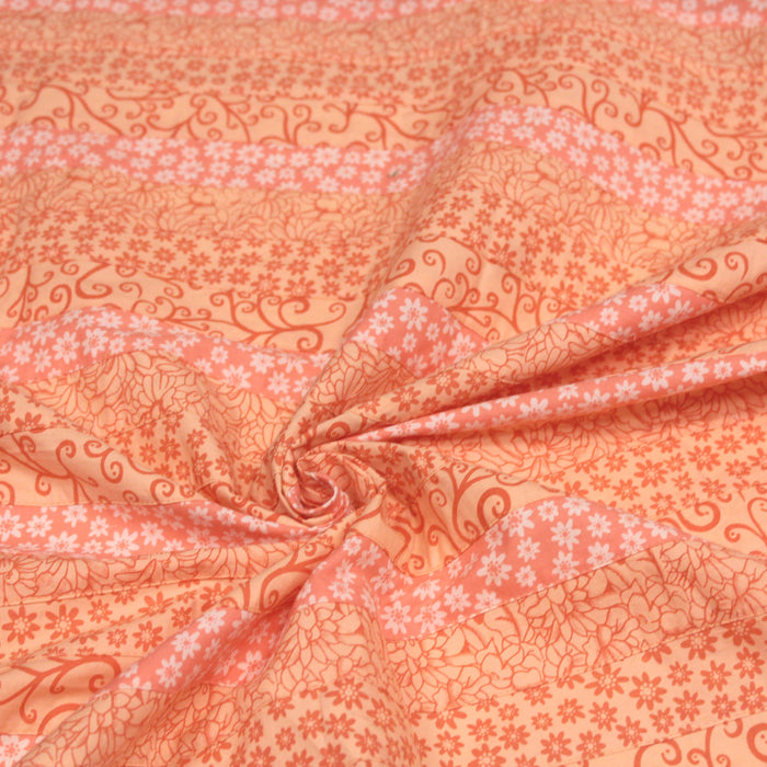 Tissu de coton batik patchwork aux fleurs variées, tons orange et pêche