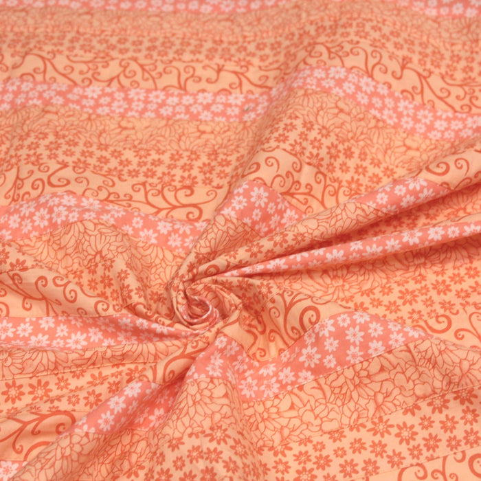 Tissu de coton batik patchwork aux fleurs variées, tons orange et pêche - TissusPapi.com