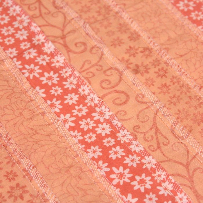 Tissu de coton batik patchwork aux fleurs variées, tons orange et pêche - TissusPapi.com
