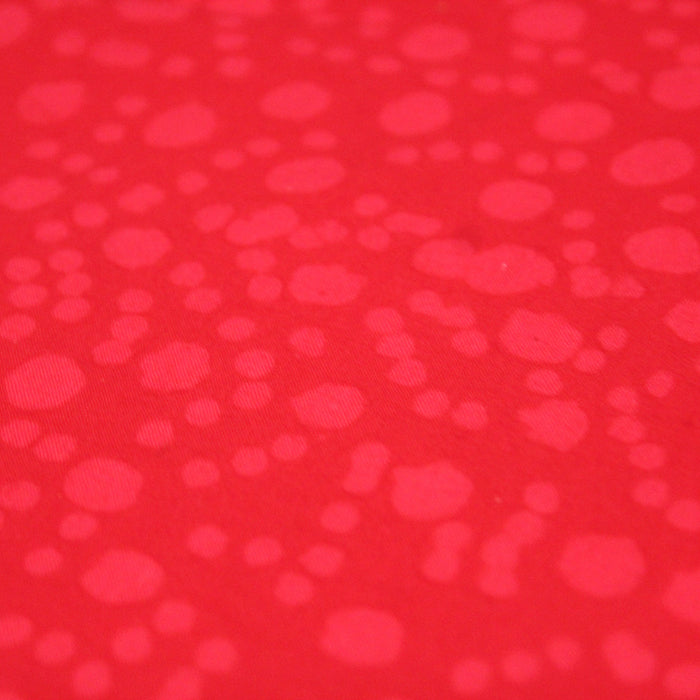 Tissu de coton batik gaufré OCÉANIE aux fleurs et taches rouges clair, fond rouge - tissuspapi
