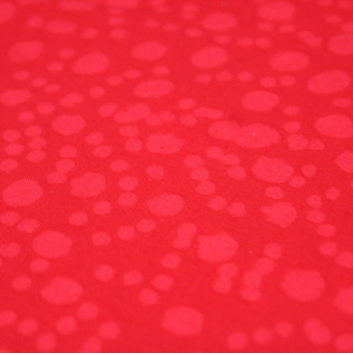 Tissu de coton batik gaufré OCÉANIE aux fleurs et taches rouges clair, fond rouge - TissusPapi.com