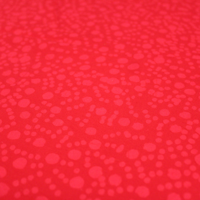 Tissu de coton batik gaufré OCÉANIE aux fleurs et taches rouges clair, fond rouge