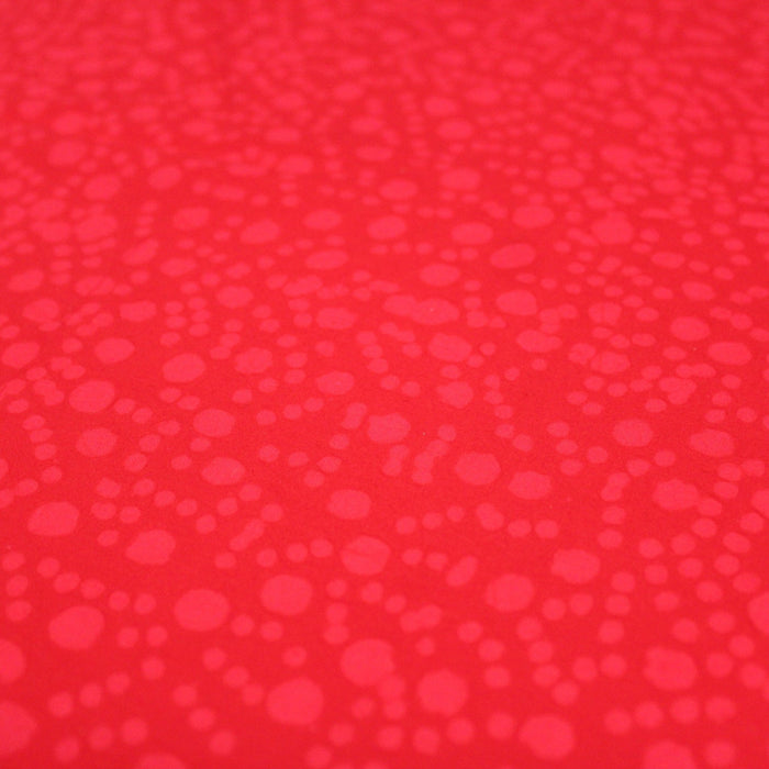 Tissu de coton batik gaufré OCÉANIE aux fleurs et taches rouges clair, fond rouge - TissusPapi.com