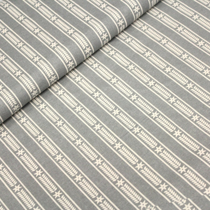 Tissu de coton de Noël scandinave aux étoiles de neiges écrues, fond gris - TissusPapi.com