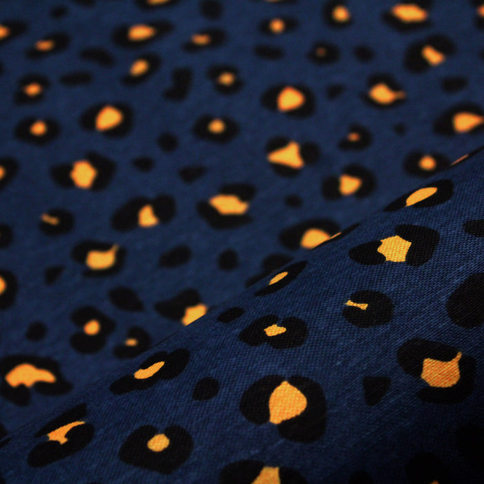 Tissu de coton motif léopard aux taches jaune safran & noir, fond bleu pétrole - Oeko-Tex