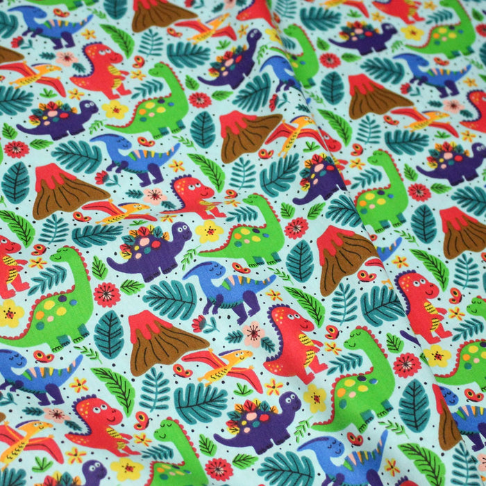 Tissu popeline coton bleu ciel aux dinosaures multicolores - TissusPapi.com
