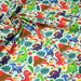 Tissu popeline coton bleu ciel aux dinosaures multicolores - TissusPapi.com