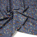 Tissu popeline coton bleu aux fins pois noirs et fines fleurs multicolores - TissusPapi.com