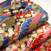 Tissu cotonnade motif japonais traditionnels : fleurs de cerisier, nuages et motifs géométriques dorés, fond bleu / rouge - COLLECTION JAPON DORÉ - TissusPapi.com