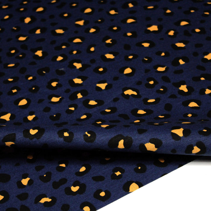 Tissu de coton motif léopard aux taches jaune safran & noir, fond bleu pétrole - Oeko-Tex