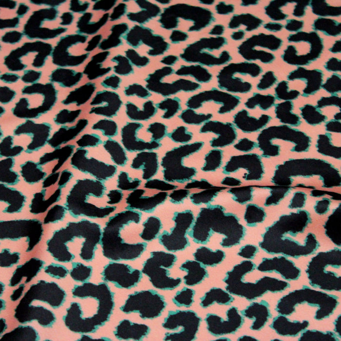 Tissu Velours ras motif léopard noir fond rose