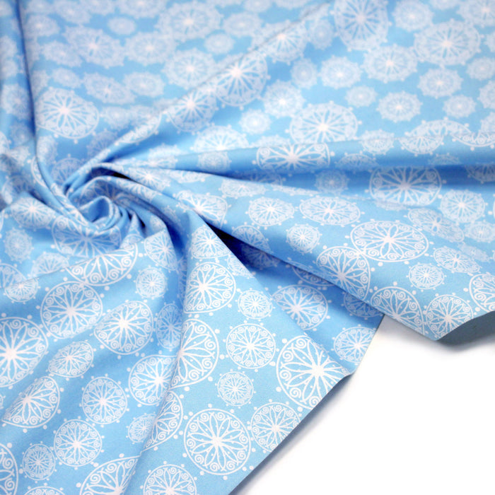 Tissu de Noël cotonnade bleu ciel aux rosaces blanches