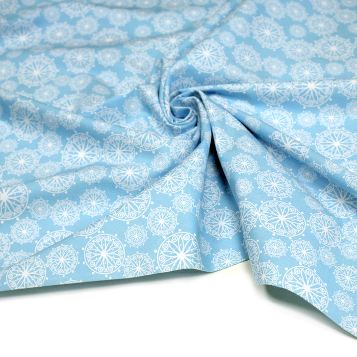 Tissu de Noël cotonnade bleu ciel aux rosaces blanches