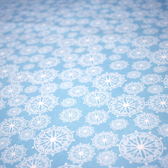 Tissu de Noël cotonnade bleu ciel aux rosaces blanches