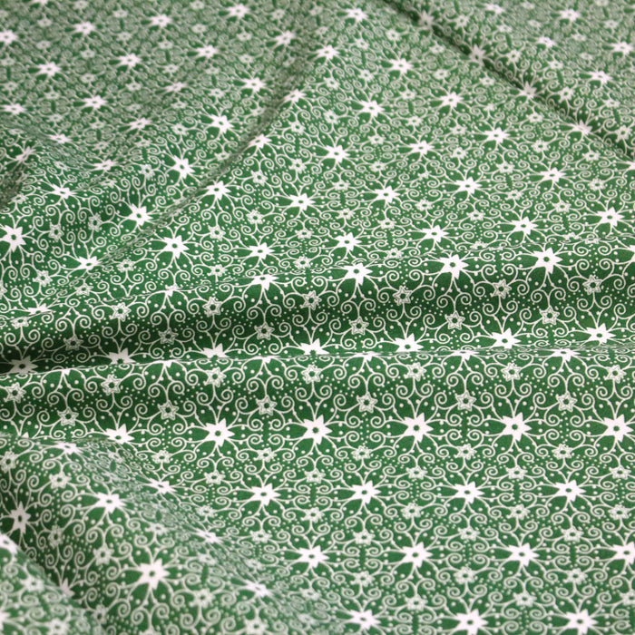 Tissu de Noël cotonnade vert aux motifs géométriques blancs de Noël