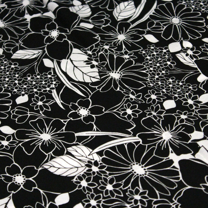 Tissu viscose fluide fond noir aux fleurs et feuilles blanches et noires - OEKO-TEX®