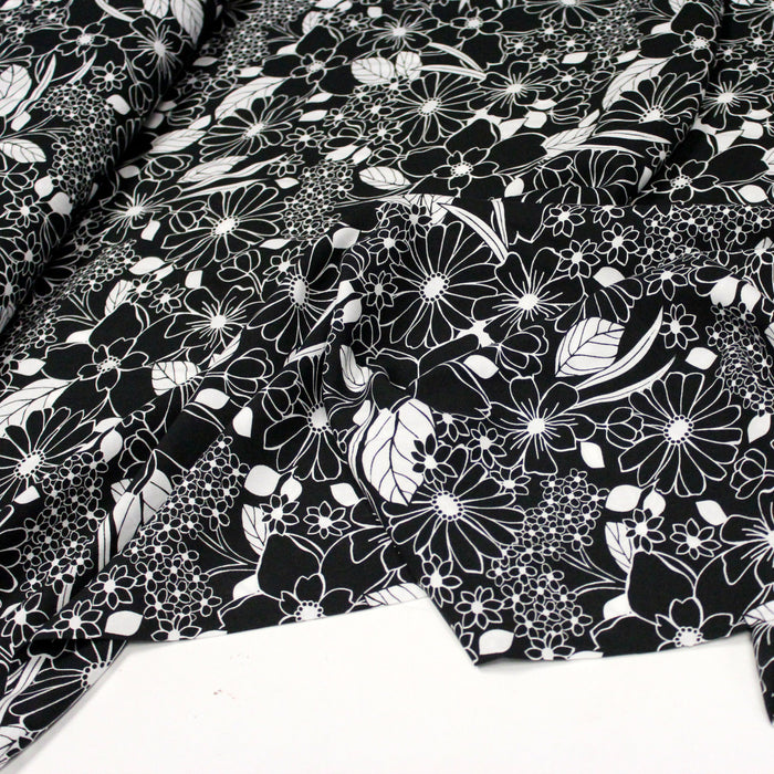 Tissu viscose fluide fond noir aux fleurs et feuilles blanches et noires - OEKO-TEX®
