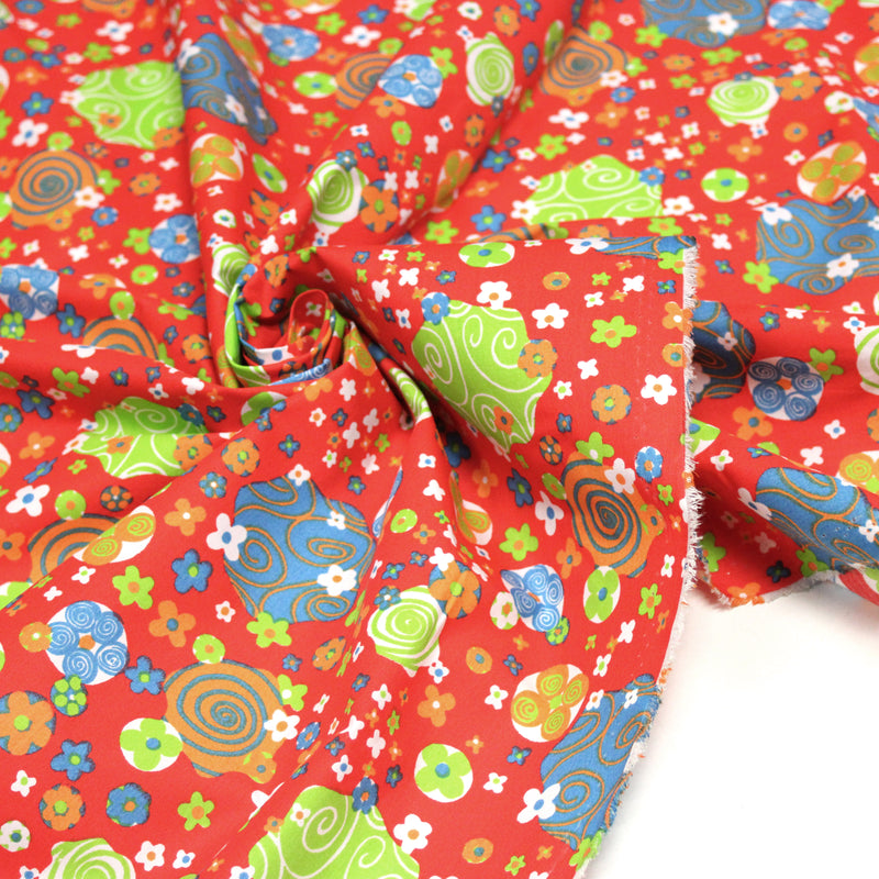 Tissu cotonnade SEVENTIES rouge et formes psychédéliques oranges, bleues, vertes