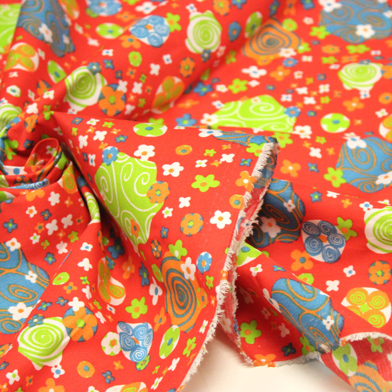 Tissu cotonnade SEVENTIES rouge et formes psychédéliques oranges, bleues, vertes