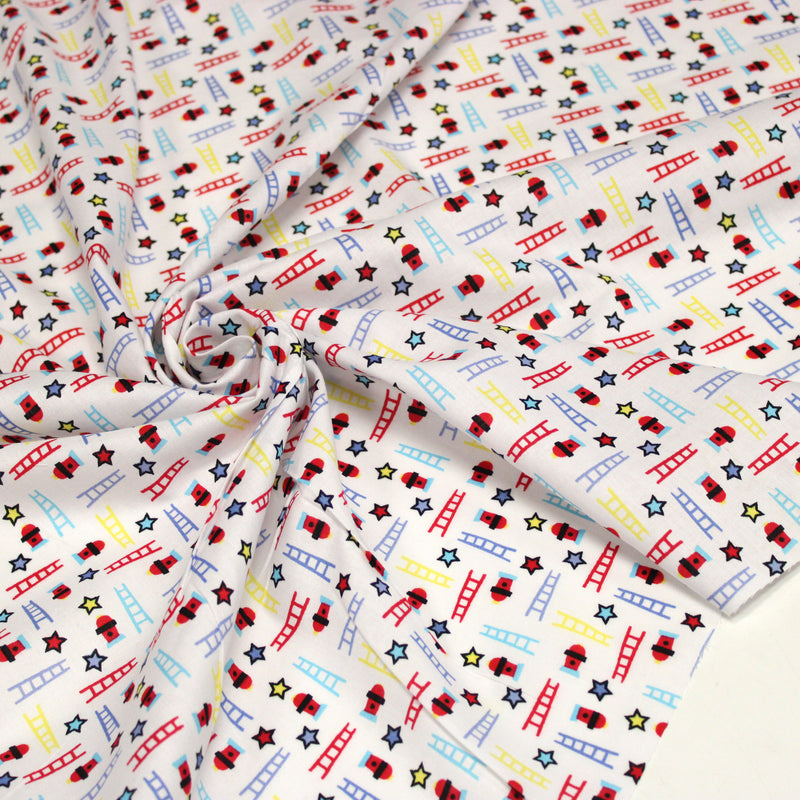 Tissu cotonnade enfant motif pompiers, échelles et étoiles multicolores sur fond blanc
