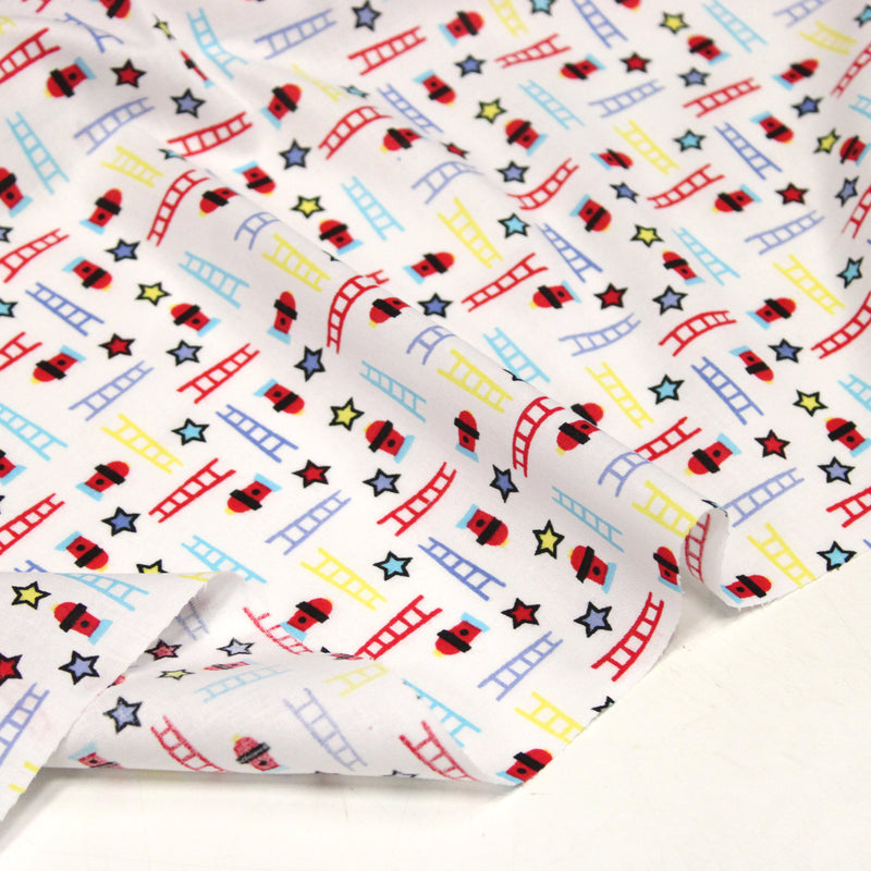 Tissu cotonnade enfant motif pompiers, échelles et étoiles multicolores sur fond blanc
