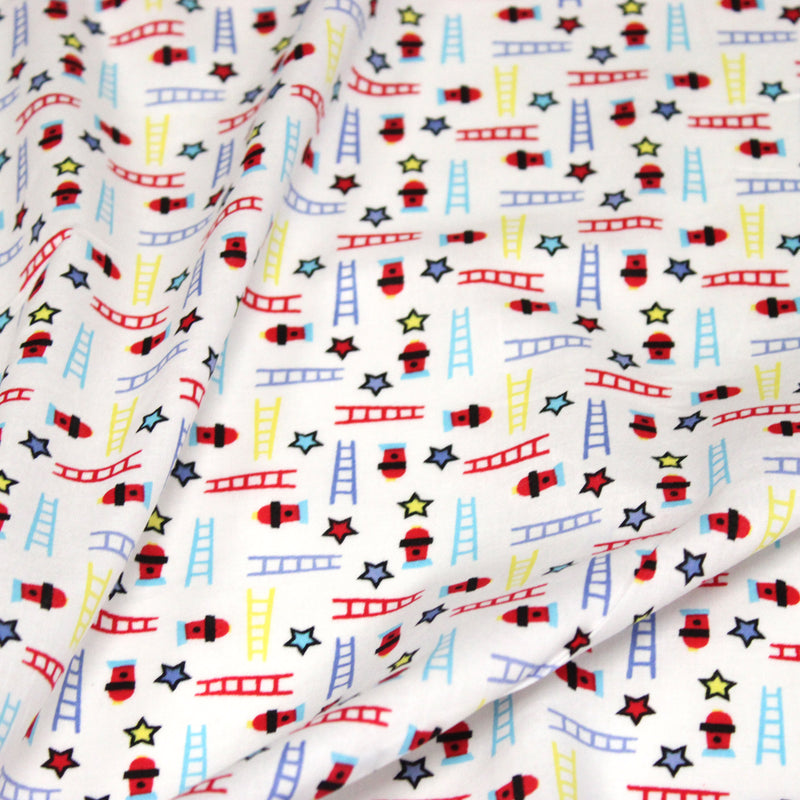 Tissu cotonnade enfant motif pompiers, échelles et étoiles multicolores sur fond blanc