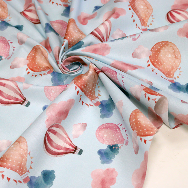 Tissu cotonnade enfant aux montgolfières roses et nuages sur fond bleu ciel
