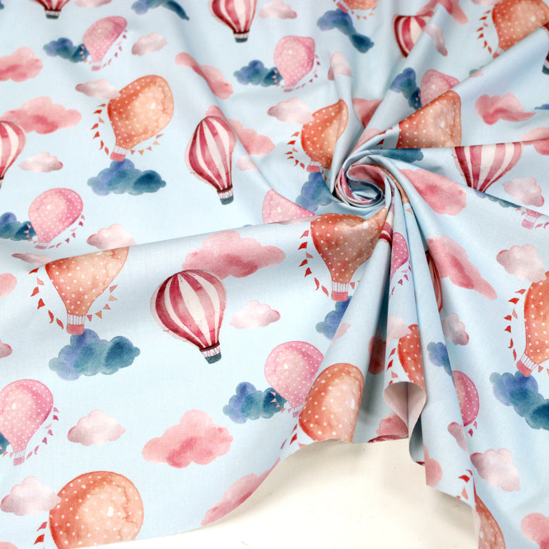 Tissu cotonnade enfant aux montgolfières roses et nuages sur fond bleu ciel