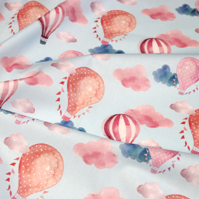 Tissu cotonnade enfant aux montgolfières roses et nuages sur fond bleu ciel