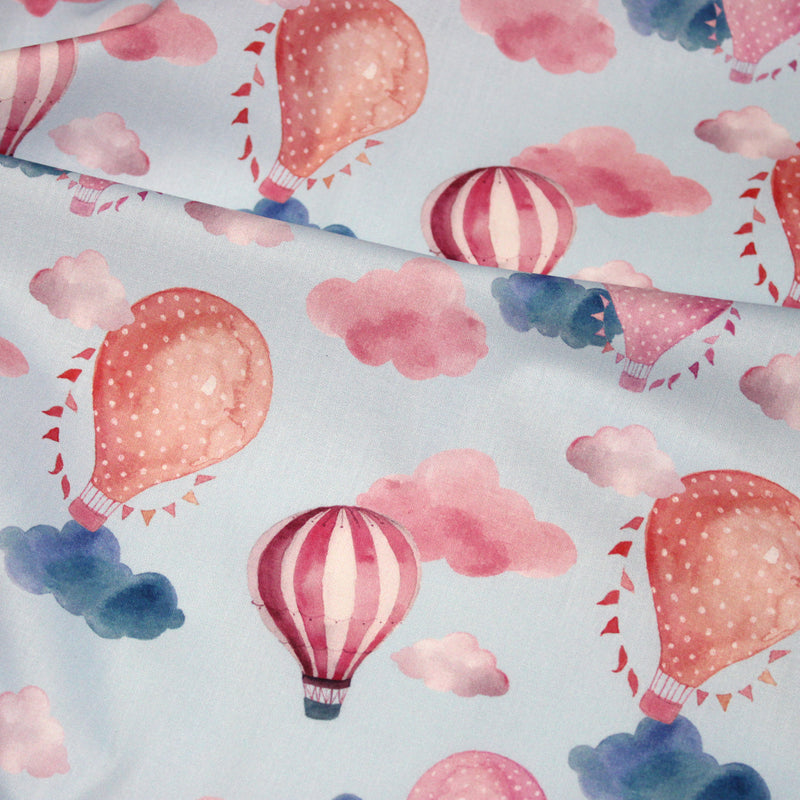 Tissu cotonnade enfant aux montgolfières roses et nuages sur fond bleu ciel