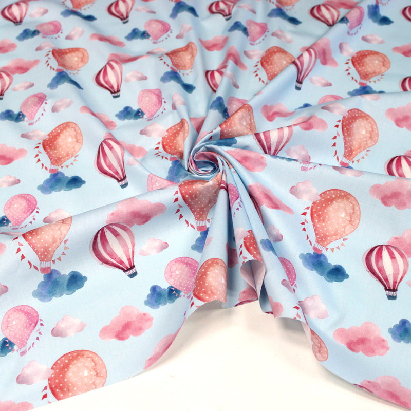 Tissu cotonnade enfant aux montgolfières roses et nuages sur fond bleu ciel