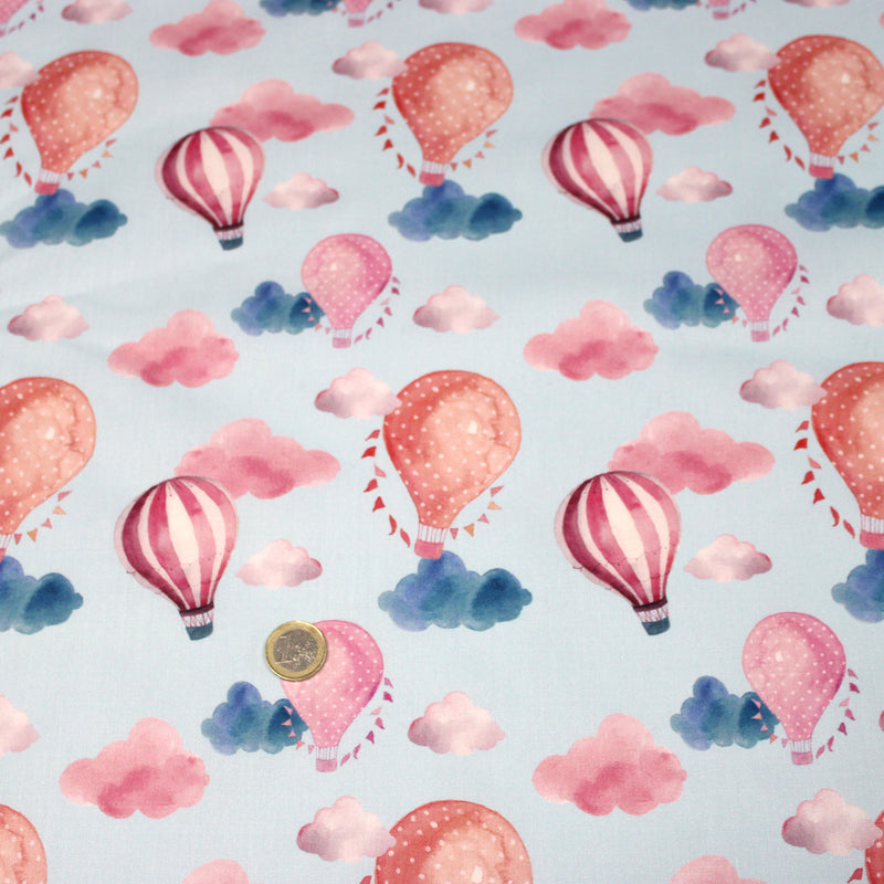 Tissu cotonnade enfant aux montgolfières roses et nuages sur fond bleu ciel